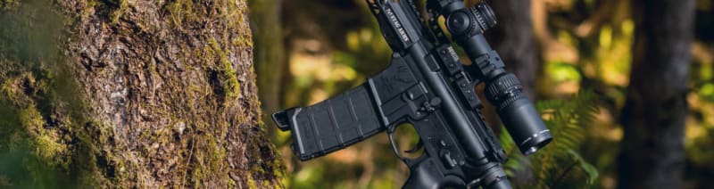 The Stag 15 3-Gun Series rifle leaning on a tree